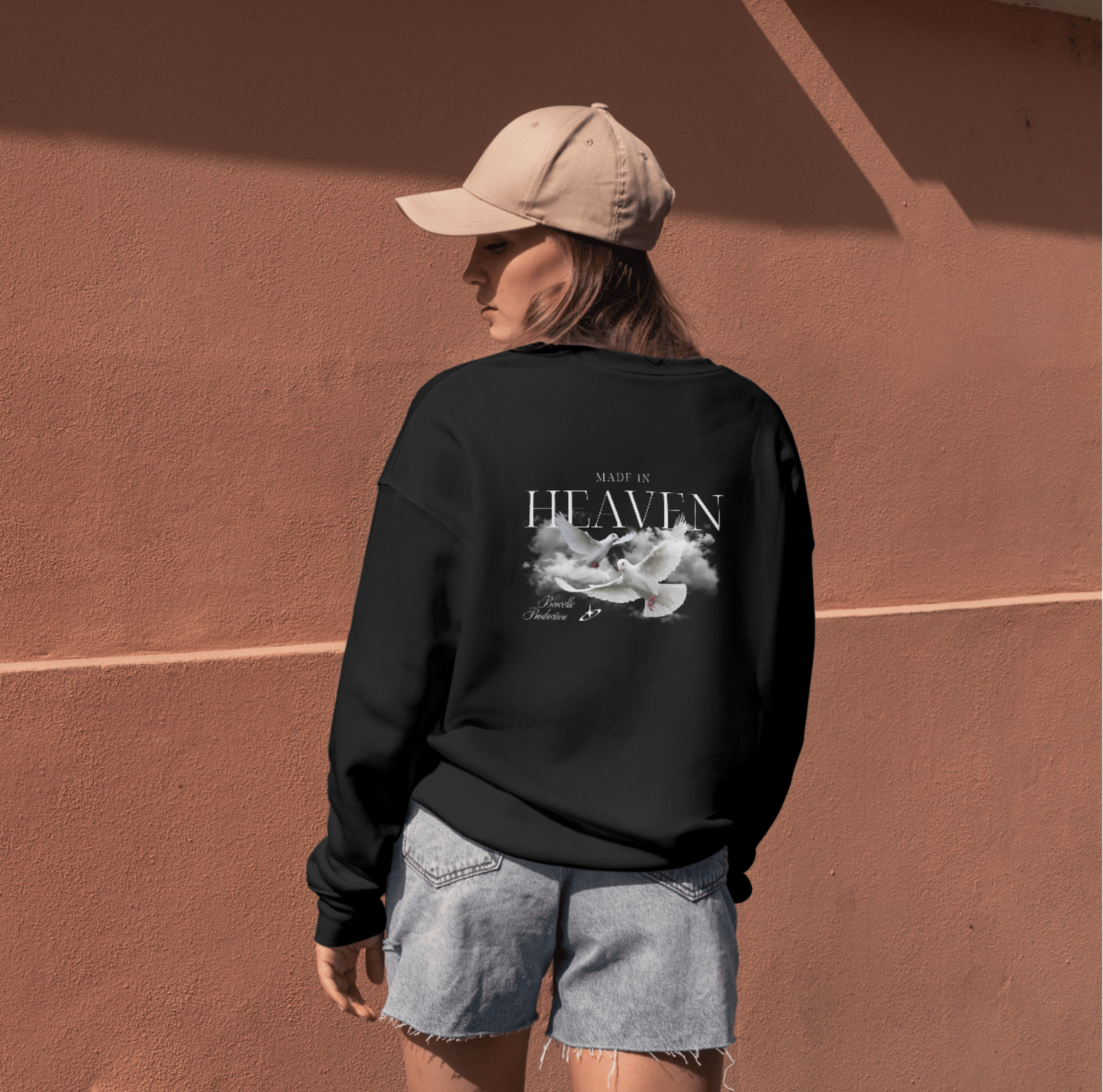 Person wearing a black sweatshirt with a graphic design on a brown surface